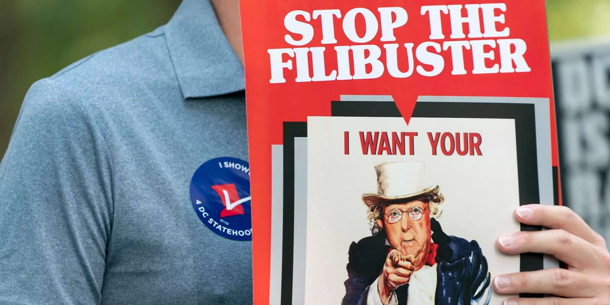 A man holds an anti-filibuster sign with the a depiction of Senate Minority Leader Mitch McConnell of R-Ky., on it, during a rally in support of voting rights, Tuesday, Sept. 14, 2021, on Capitol Hill in Washington.