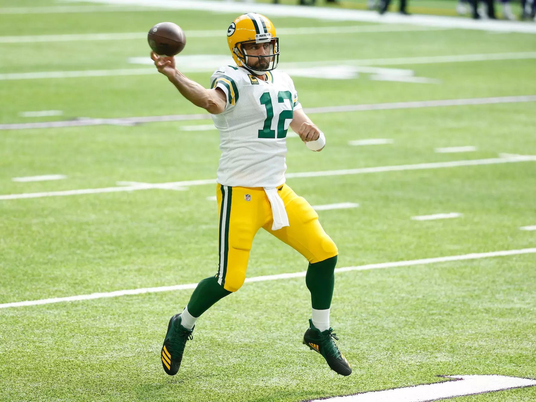 Aaron Rodgers makes a throw while jumping in the air.