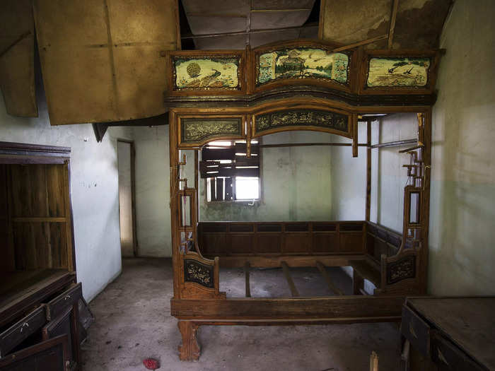 A bed and other furniture are left inside a small apartment at the abandoned fishing village of Houtouwan, China, on the island of Shengshan.