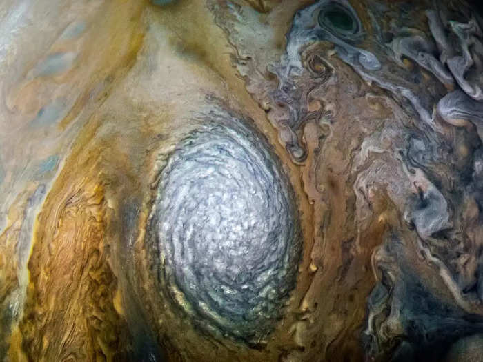 Cyclones spin in the same direction as the planet, but anticyclones spin in the opposite direction. Both are found all over Jupiter, in varying sizes.