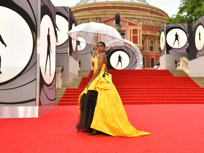 Lashana Lynch, who plays 00 agent Nomi, keeps dry on the red carpet with an unbrella.