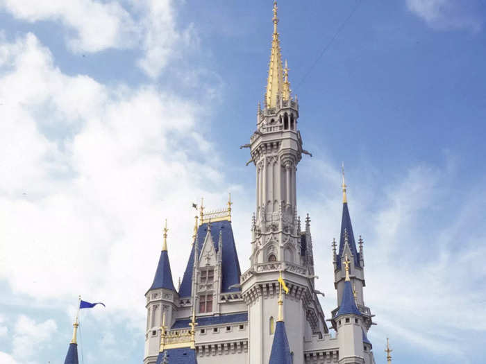 The castle is typically painted with a gray hue and topped with dark-blue spires. There are also often flags surrounding the landmark.