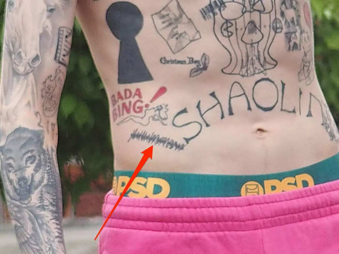 He has a black scribble tattooed on his right hip.