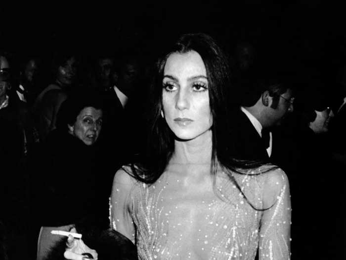 Cher turned heads in a sparkly, sheer Bob Mackie dress that had a feather trim at the 1974 Met Gala.