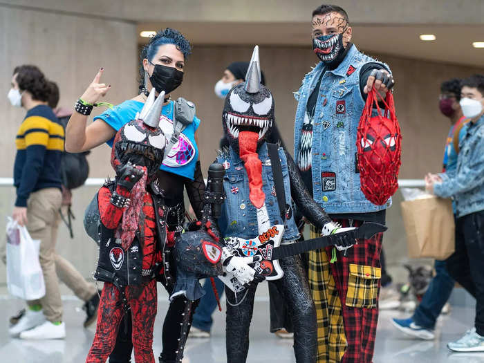 A group of four cosplayers dressed as rocker versions of Venom and Carnage.