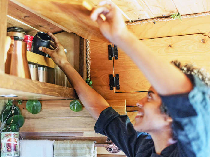 Above the cabinets, extra shelving stores other items like alcohol and salt-and-pepper shakers.