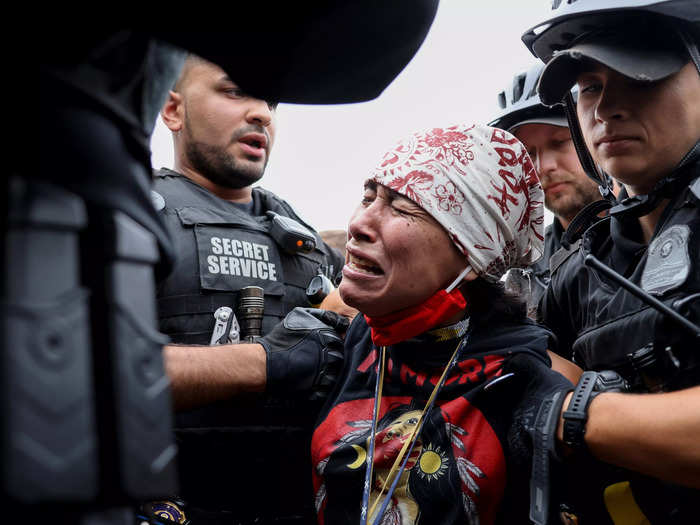 A protestor was grabbed and shuffled away by police for reportedly throwing something over the fence of the White House.