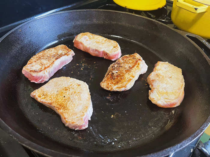 I placed the pork chops in a hot cast-iron pan with a tablespoon of olive oil and seared them on both sides.