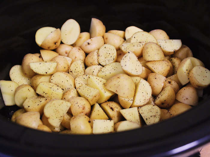 After placing chopped potatoes into the slow cooker, I sprinkled them with a bit of pepper.