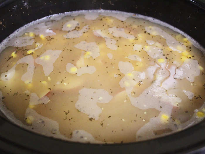 I then added in most of the other ingredients, including chicken broth, two and a half cans of canned corn, thyme, dried basil, and onion powder.