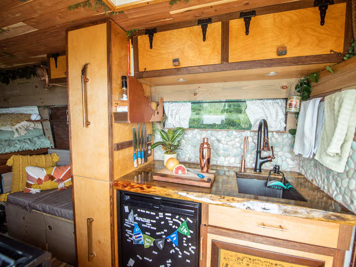 One side of the kitchen has a fridge and a sink with storage cabinets above.