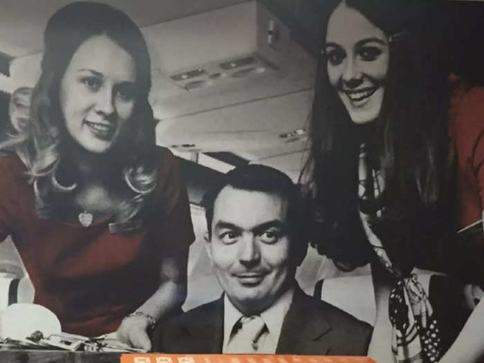 Early flight attendants posing with passengers...