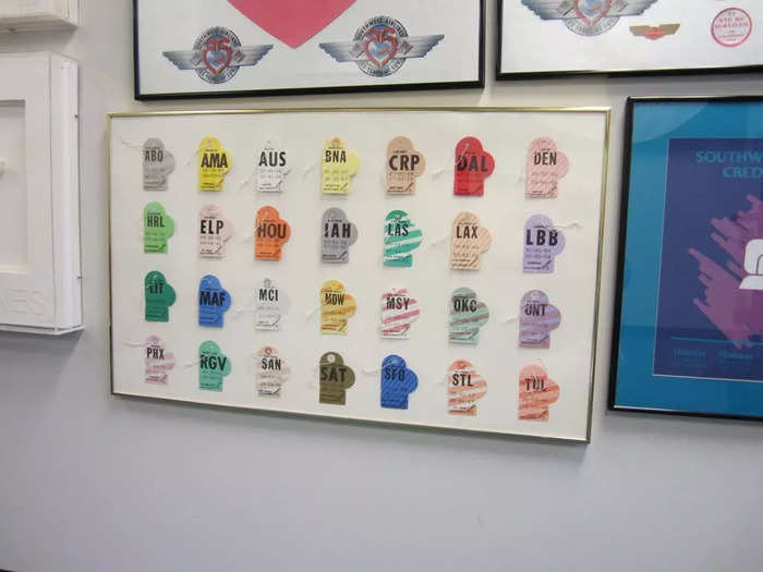 A framed display of nearly 30 heart-shaped bag tags from the 70s...
