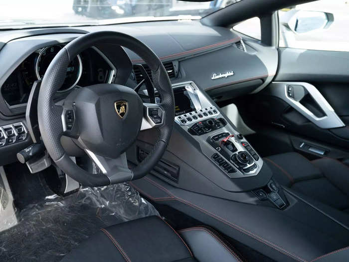 According to the listing, the Lambo shows fewer than 2,000 miles and still has its protective plastic inside.