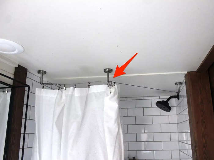 Inside the tiny house bathroom, a wire allowed the designer to curve the curtain around the inside of the shower, adding just a bit of extra space.