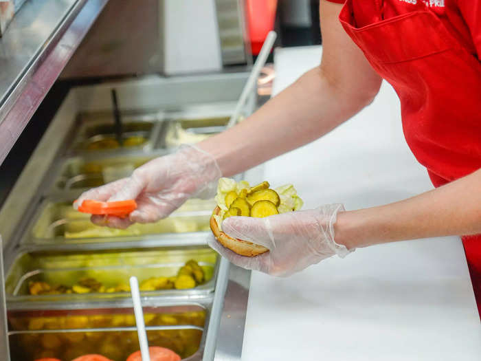 While all of that is happening on the grill, another employee dresses the bun for each order.