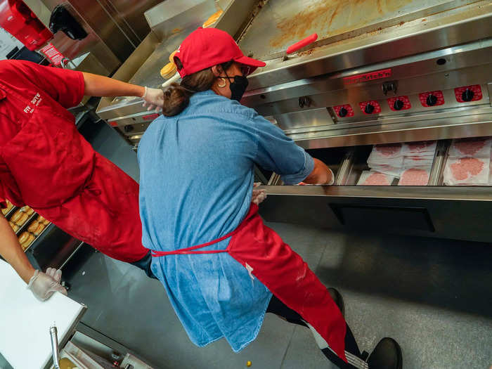 Ahead of opening the doors for customers, patties get loaded into a drawer below the grill for easy access.