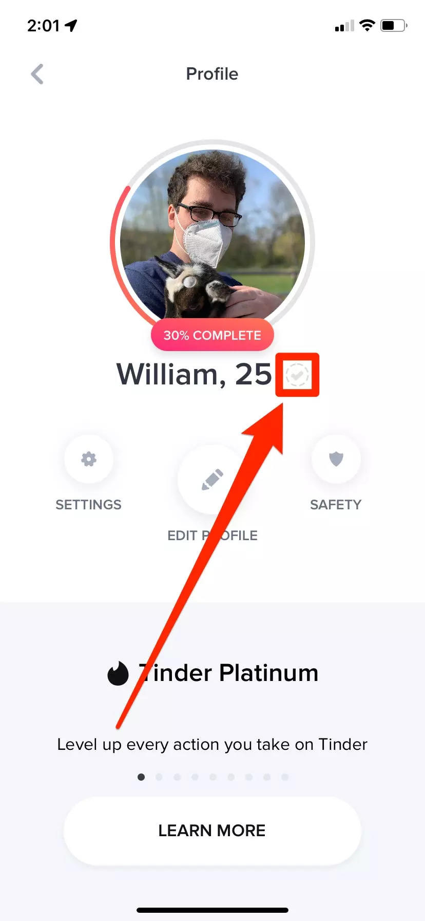 The Tinder profile of an unverified user. The gray checkmark next to their name is highlighted.