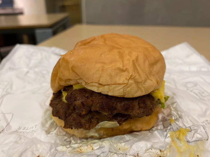 The deluxe burger comes with two 1/8-pound beef patties, cheese, lettuce, mayonnaise and pickle relish. One half of the burger looked like this, with few visible signs of the cheese, lettuce, and relish.