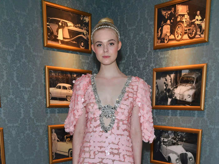 Fanning attended the 2017 Miu Miu fashion show in a pink dress with a plunging neckline and midriff cutout.