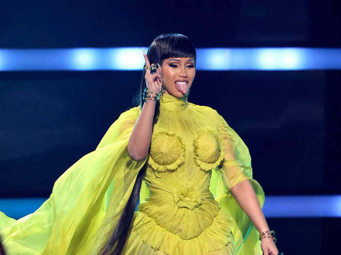 Next up, Cardi B wore a high-neck neon yellow gown with a flowing train.