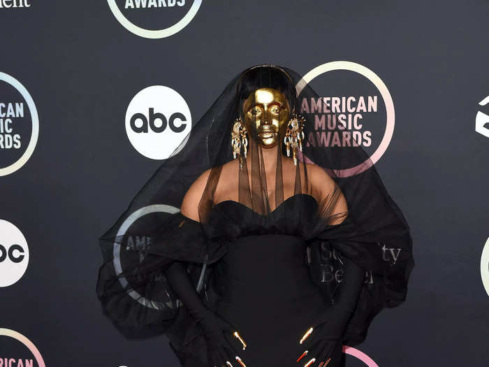 Cardi B kicked off her hosting duties at the awards show in a statement Schiaparelli look that included a gold-plated face mask.