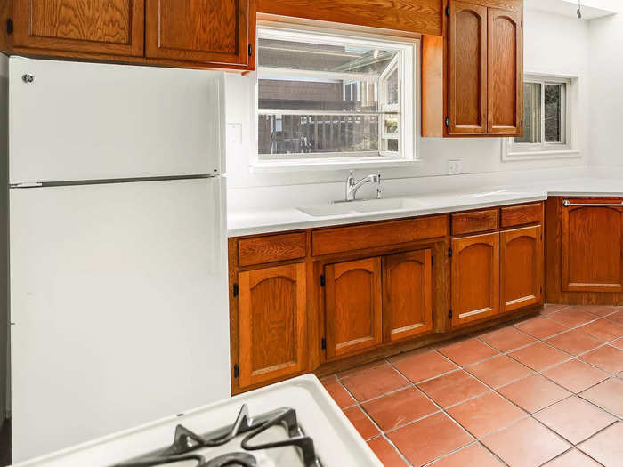 The kitchen has an oven with a gas range, sink, refrigerator, and plenty of counter space and storage.