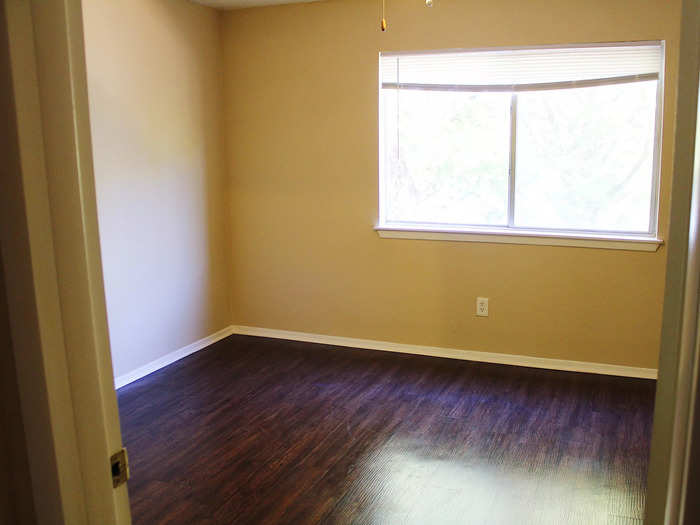 The bedroom featured wood floors and a large window.