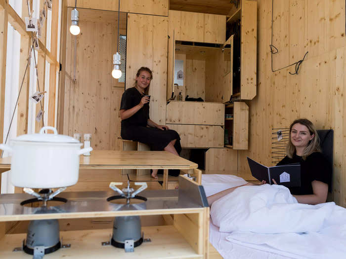 A tiny home designed by two architecture students in Berlin utilizes its entire space, with built-in shelving and storage units all over the home.