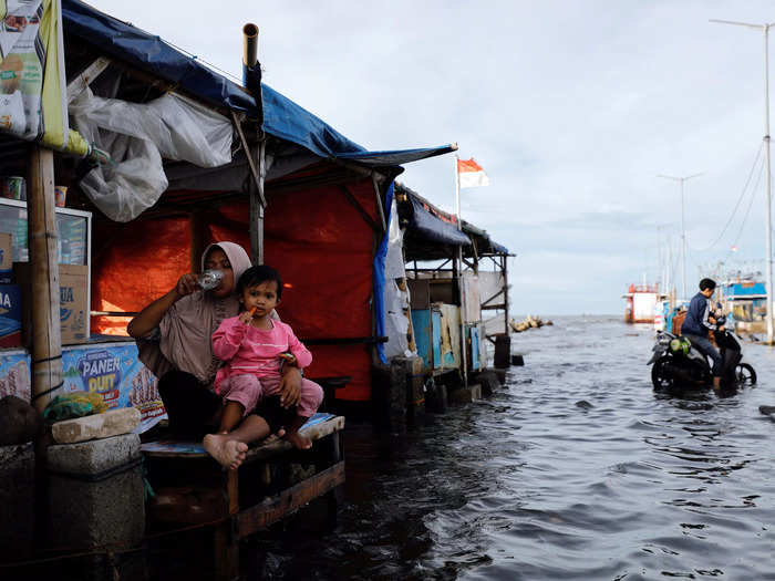 In Indonesia, vendors like Zuriati, 42, worked through flooding caused by high tides in Jakarta.