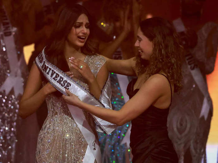 She stood with an expression of disbelief as her Miss Universe sash was placed over her shoulder.