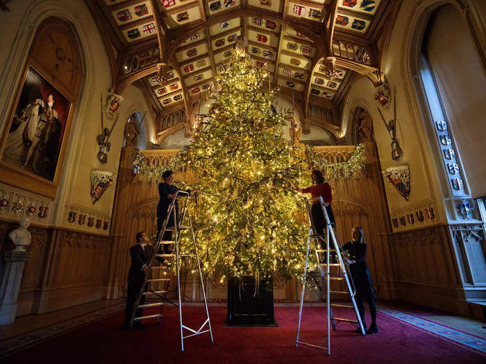 The palace staff works hard to deck the halls and hang luminous ornaments on Christmas trees.