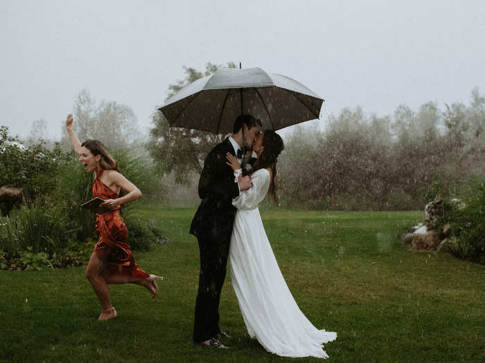 While one wedding guest simply ran through the rain, the bride and groom came prepared with an umbrella at their Ontario wedding.