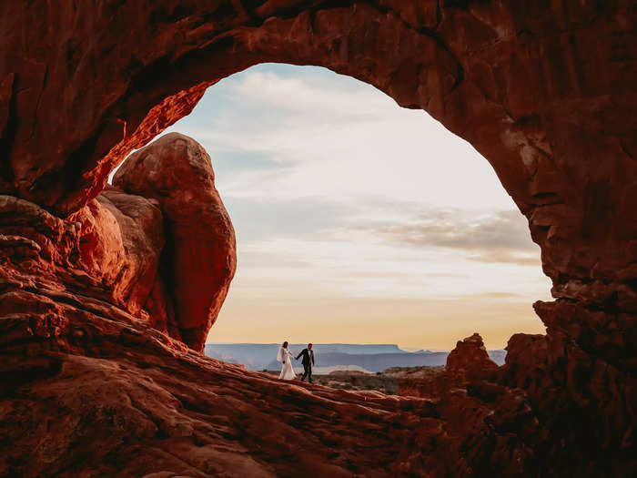 An arch inside Arches National Park in Moab, Utah, provides a natural frame for the couple.