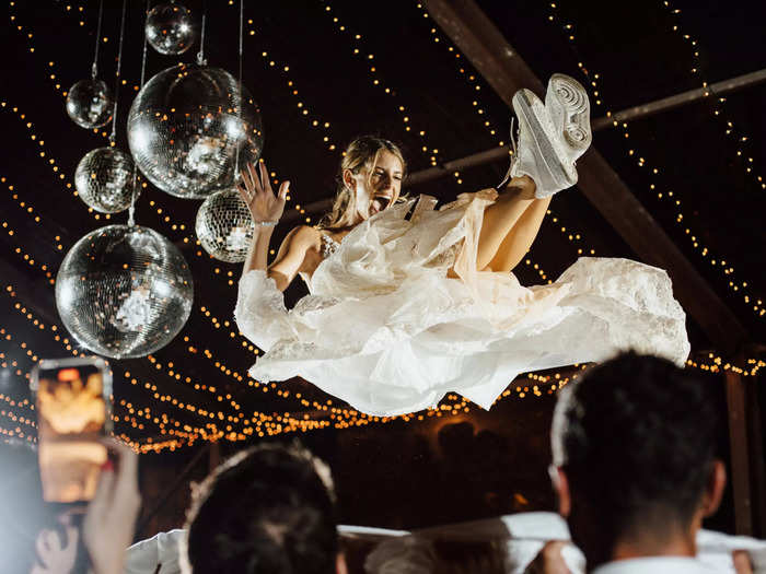 This bride loved her crowd-surfing moment complete with disco balls and sneakers at the Hotel Esencia in Tulum, Mexico.