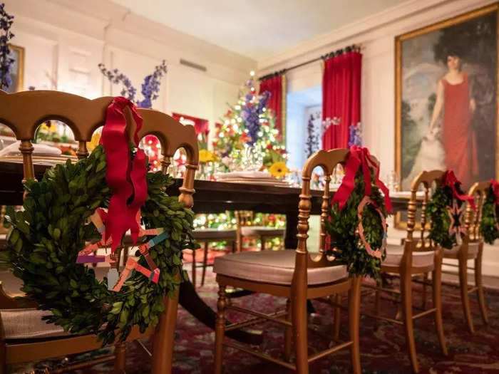 In the China Room, wreaths comprised of interlocking hands hang on dining chairs.