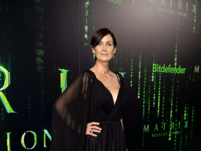 "The Matrix Resurrections" star Carrie-Ann Moss wore a long black gown, with sheer sleeves and sparkling details at the bottom.