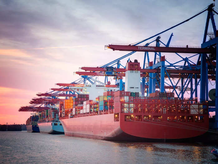 Massive cranes that hang over the ship unload the containers.