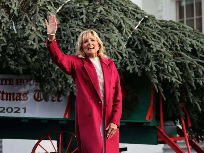 Dr. Jill Biden welcomed the 2021 White House Christmas Tree in a magenta coat over a cream dress.