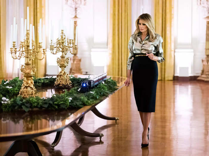 She showed off the 2020 White House Christmas decorations in a gold Dries Van Noten shirt tucked into a black pencil skirt.