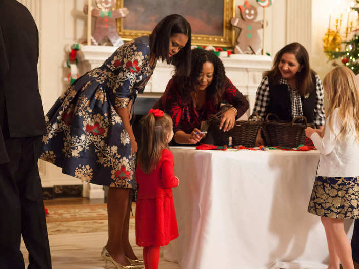 Obama welcomed military families to the White House for Christmas in a blue patterned dress in 2016.