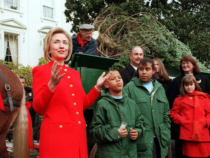 Hillary Rodham Clinton wore a red jacket with gold buttons upon the arrival of the official White House Christmas Tree in 1997.