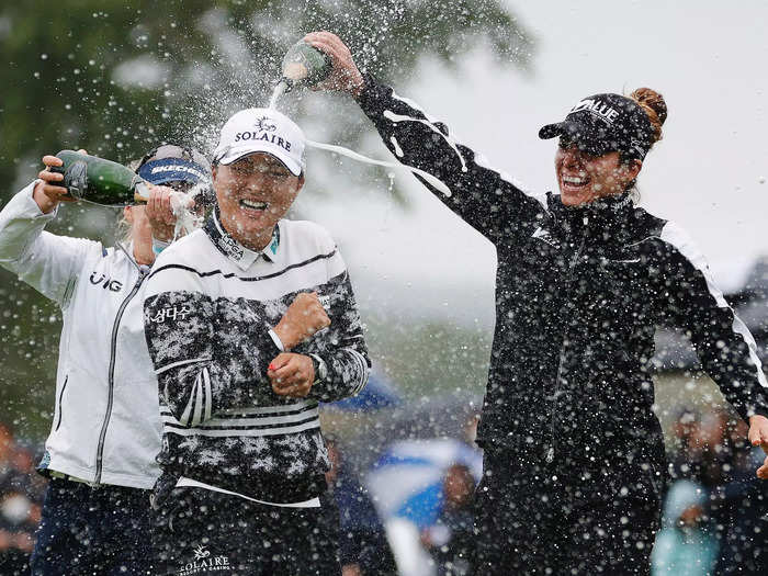 October 10: Gabby Lopez of Mexico (right) and Brooke M. Henderson of Canada (left) pour champagne on Korea