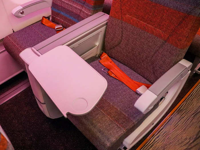 A solid tray table is also stored in the armrest, with a small drink counter in between seats.