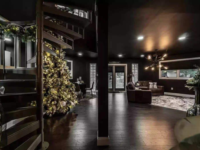 A spiral staircase in the open-plan lounge and dining room leads up to the main living loft, which has "soaring cathedral ceilings" and three skylights, according to the listing.