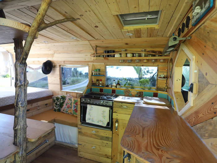 The van has a kitchen with an oven, a tap and 80-liter pump, a lounge and dining area, a bed, and a painting workshop with a desk.