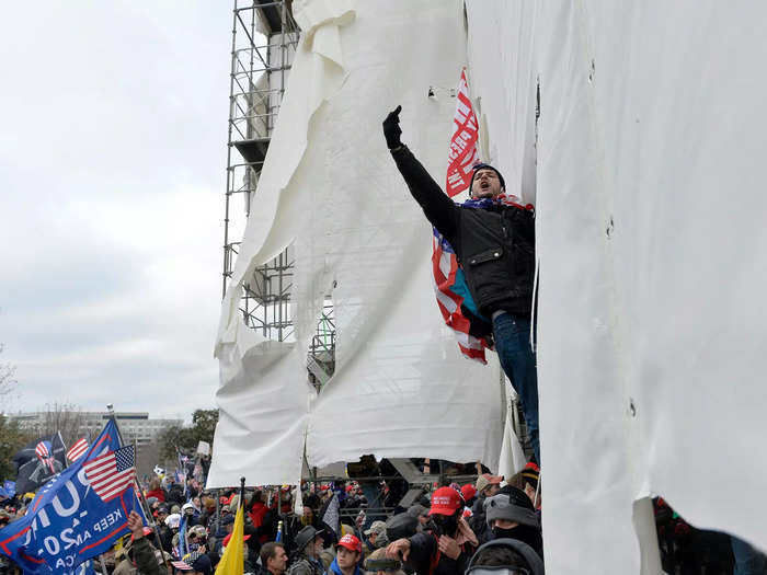 Trump supporters clash with police and security forces, climbing scaffolding as they try to storm the US Capitol.