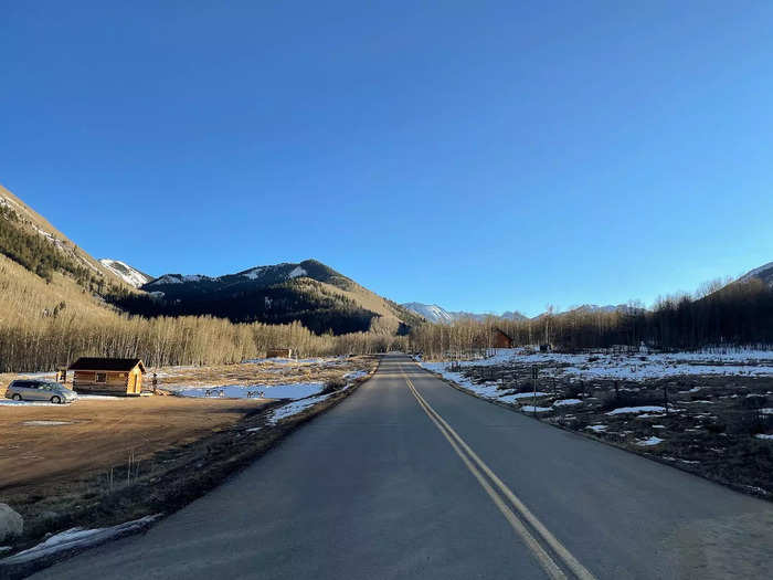 A muddy parking lot and a few wooden shacks greet visitors. But just beyond the road are the ghost town