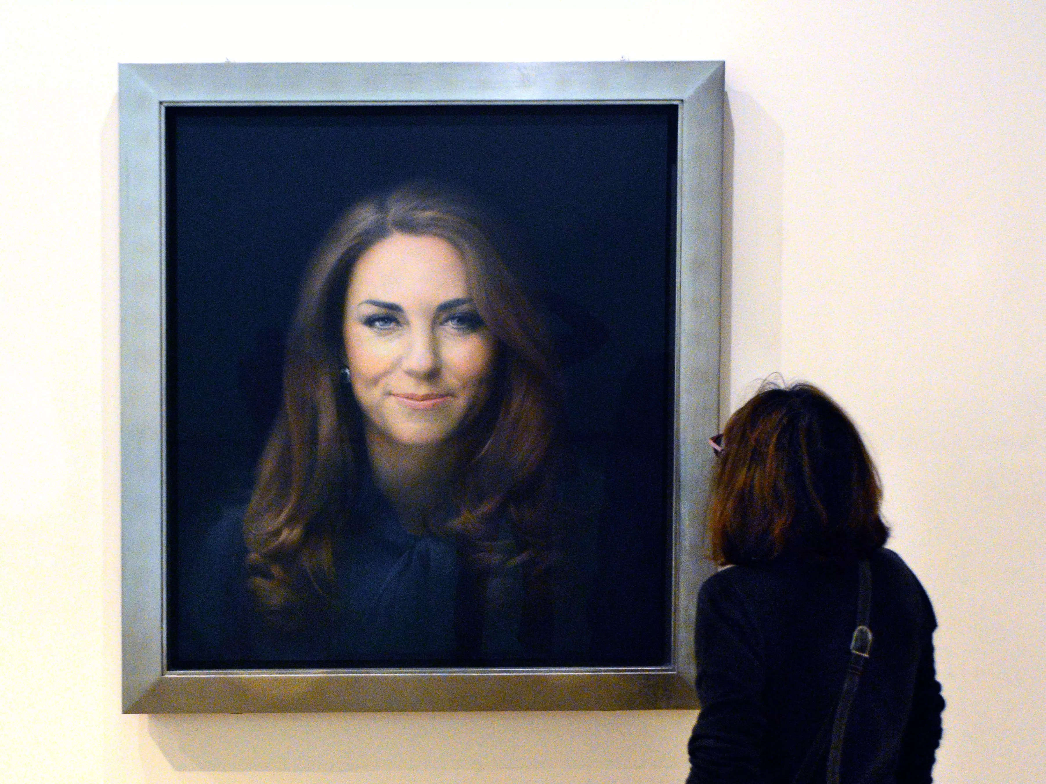 A museum visitor admires a portrait of Catherine, Duchess of Cambridge (Kate MIddleton), at the National Portrait Gallery in London, England. The official portrait was painted by British artist Paul Emsley.