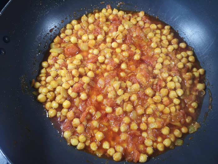 Add the bulk of the cooked chickpeas to the curry